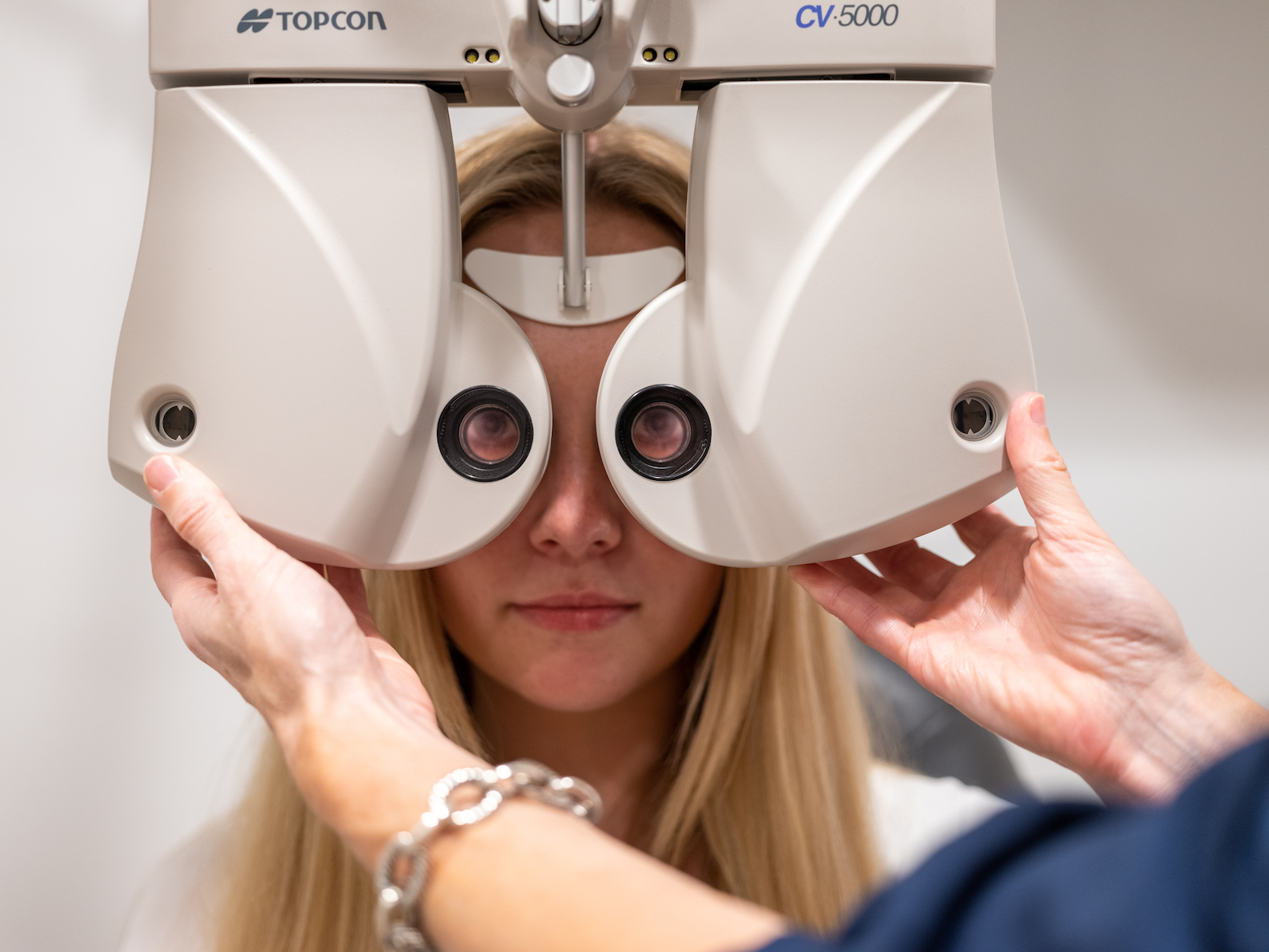 Young female patient examined by a phoropter at Downtown Vision Care in Calgary.
